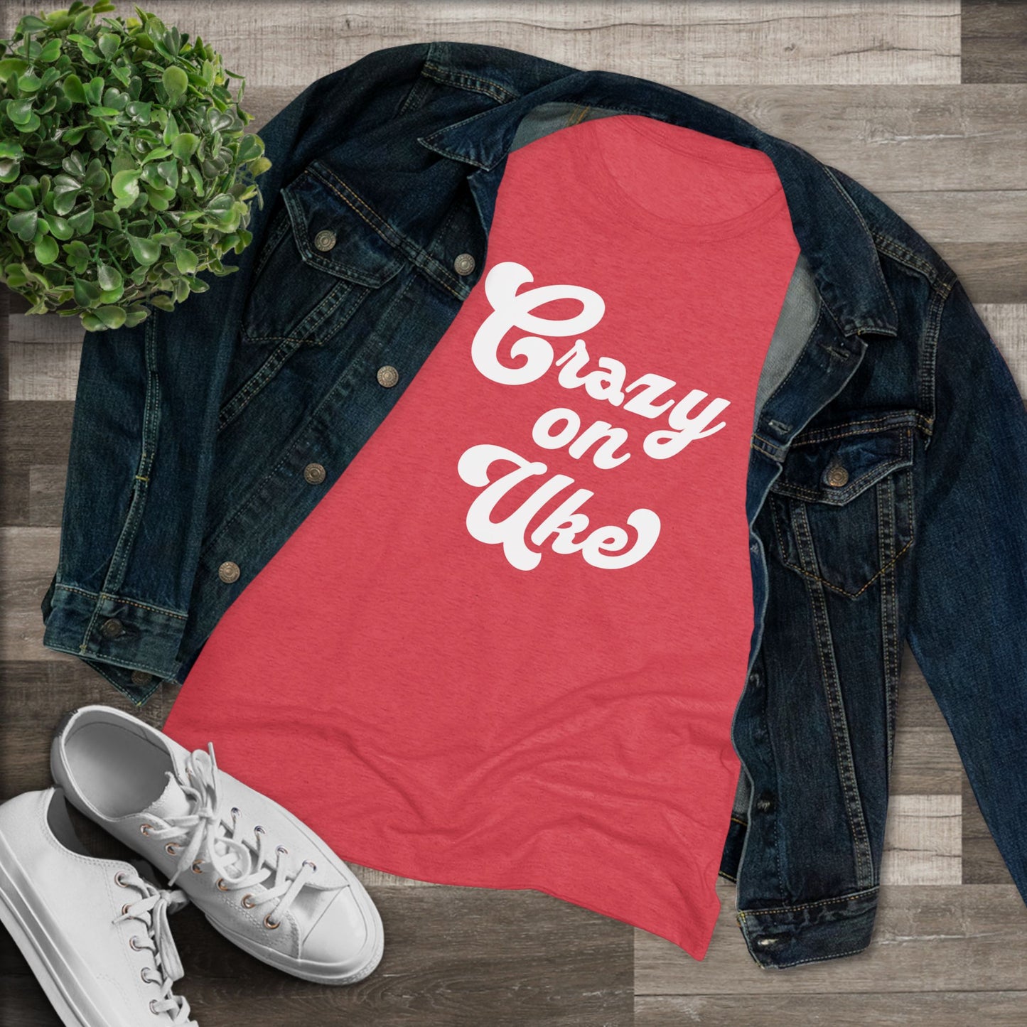 Red t-shirt with 'Crazy On Uke' in white cursive text printed on it, styled with a denim jacket and white sneakers.
