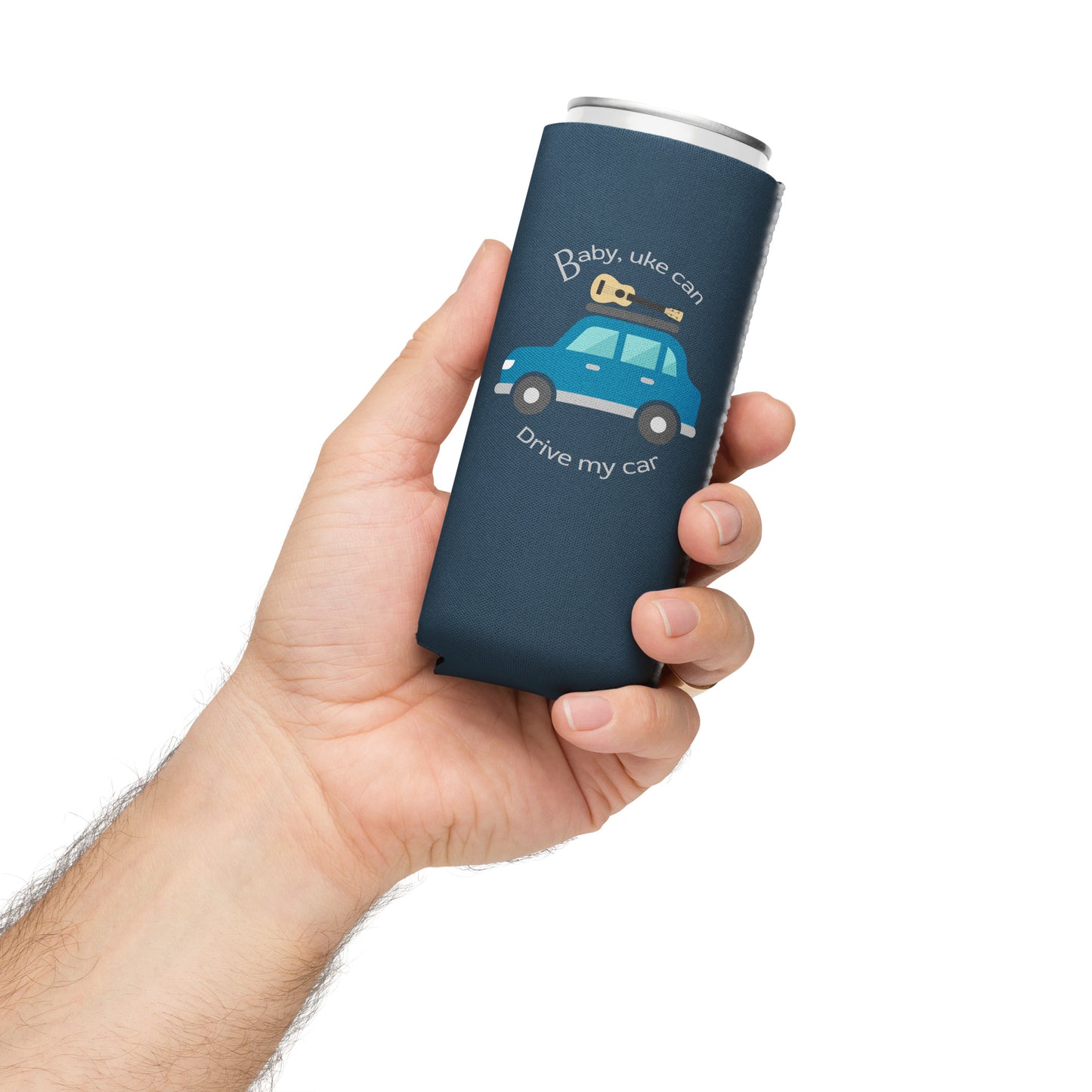 Hand holding a slim can coozie printed with an indigo background and ‘Baby, uke can drive my car’ with a graphic of a car with a ukulele on the roof.