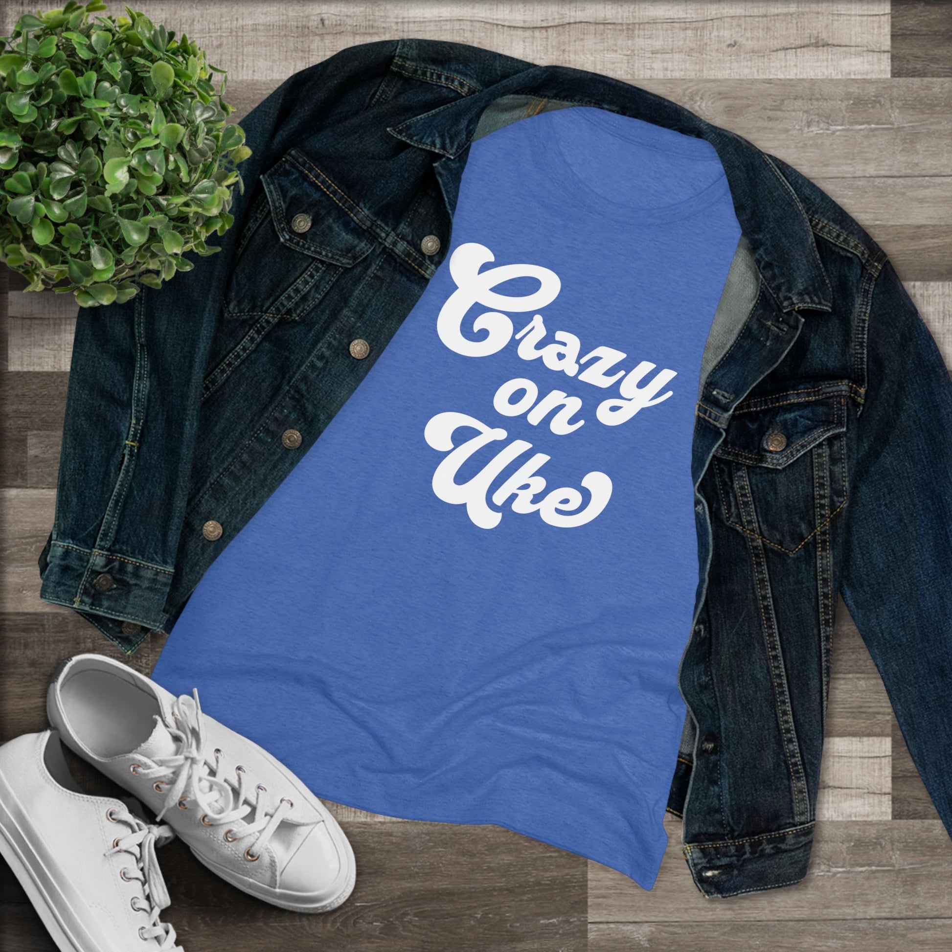 Royal blue t-shirt with 'Crazy On Uke' in white cursive text printed on it, styled with a denim jacket and white sneakers.