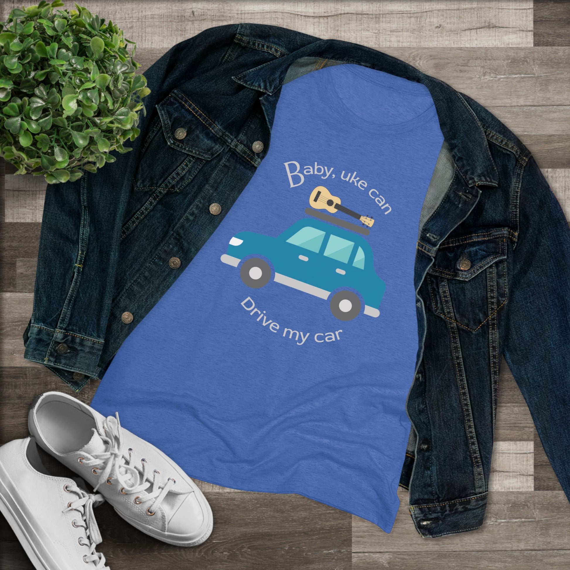 Royal blue t-shirt with ‘Baby, uke can drive my car’ and a graphic of a car with a ukulele on the roof printed on it, styled with a denim jacket and white sneakers.