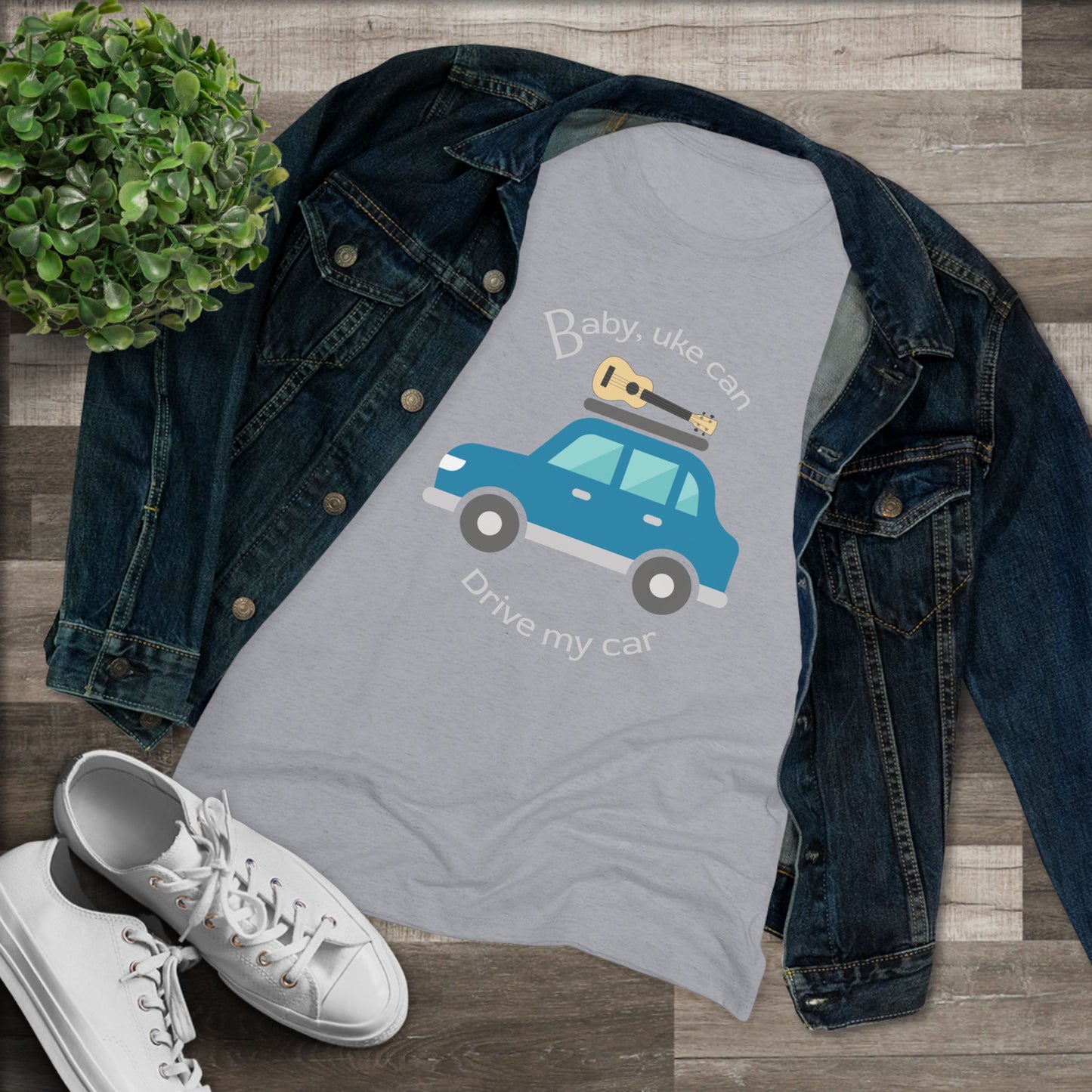 Grey t-shirt with ‘Baby, uke can drive my car’ and a graphic of a car with a ukulele on the roof printed on it, styled with a denim jacket and white sneakers.