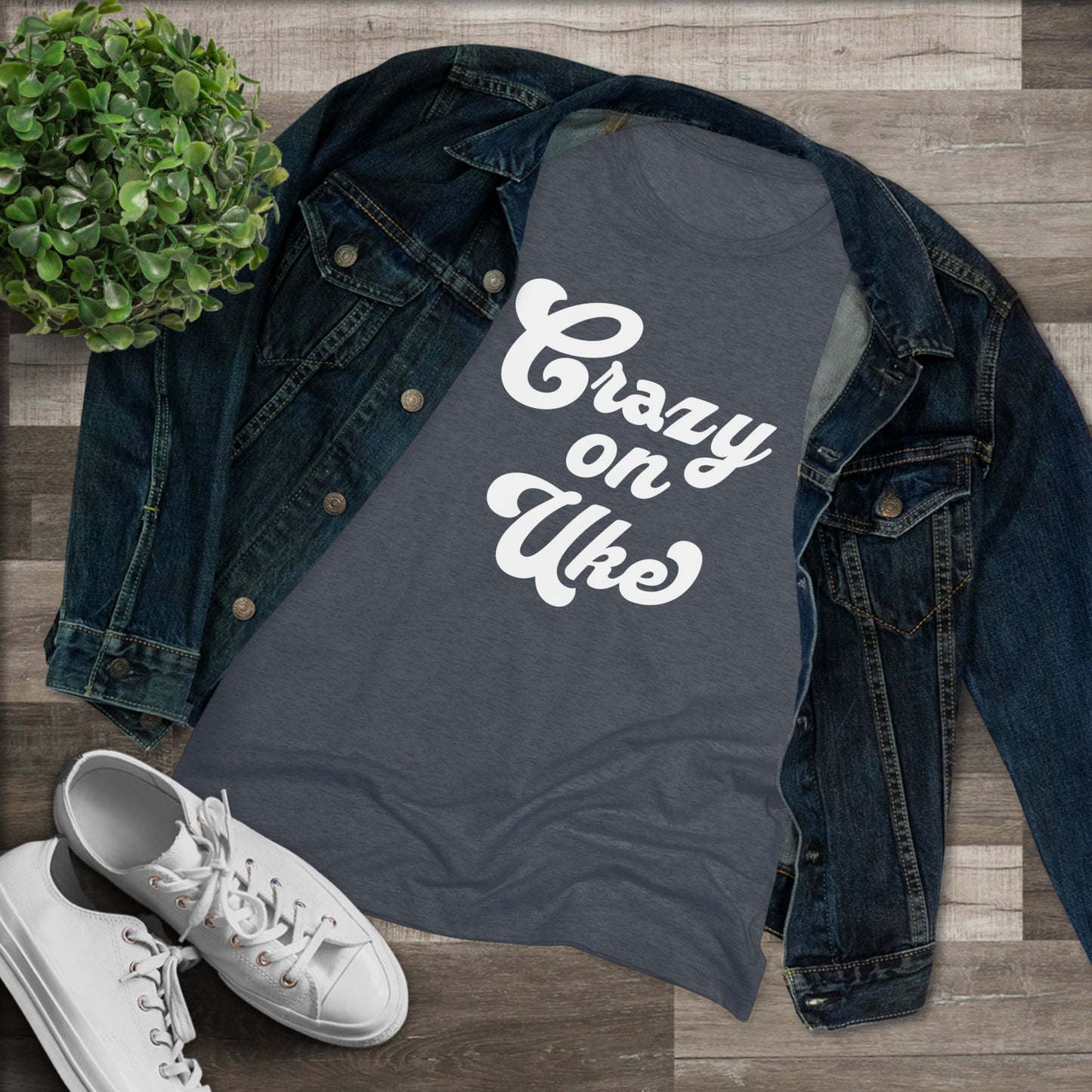 Heathered navy t-shirt with 'Crazy On Uke' in white cursive text printed on it, styled with a denim jacket and white sneakers.
