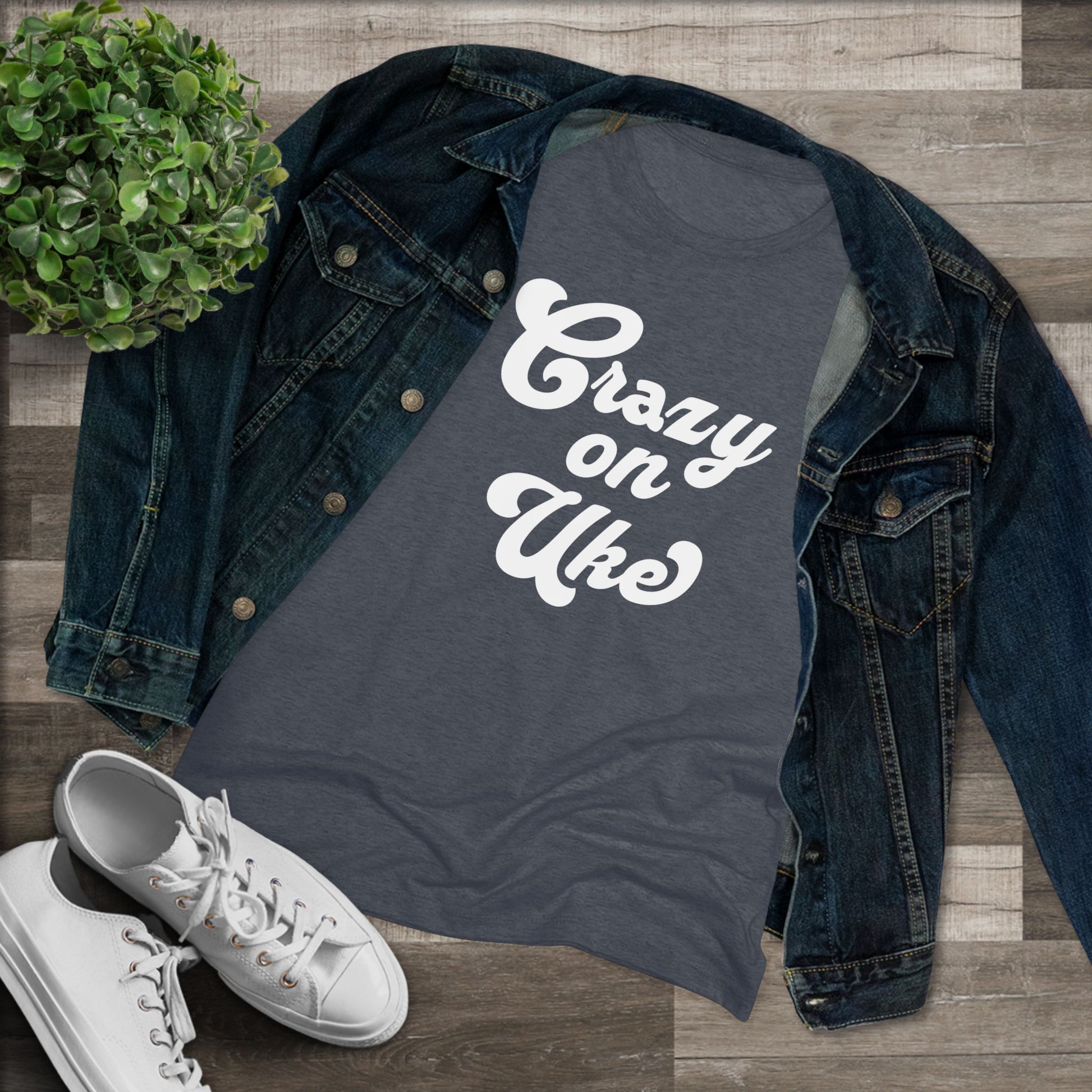 Heathered navy t-shirt with 'Crazy On Uke' in white cursive text printed on it, styled with a denim jacket and white sneakers.