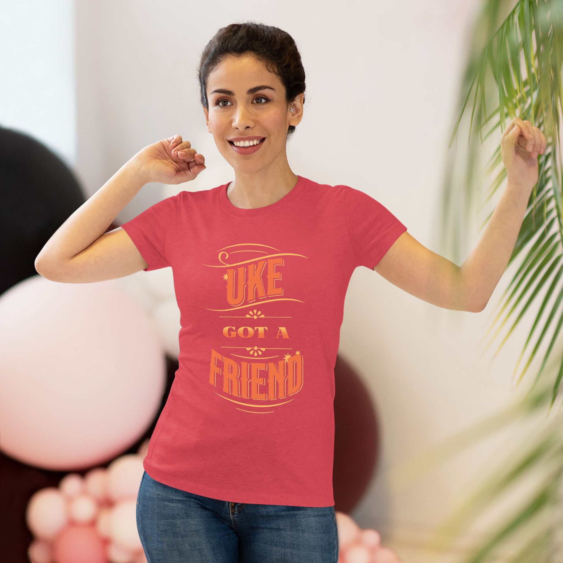 Woman wearing a red t-shirt with ‘Uke Got A Friend' in orange block letters printed on it.