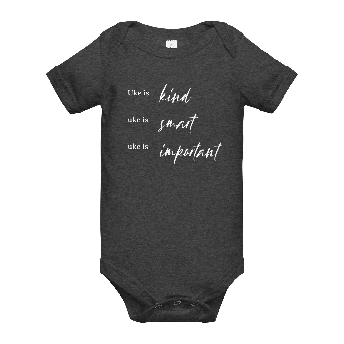 A dark grey onesie printed with 'Uke is kind, uke is smart, uke is important' in white letters.