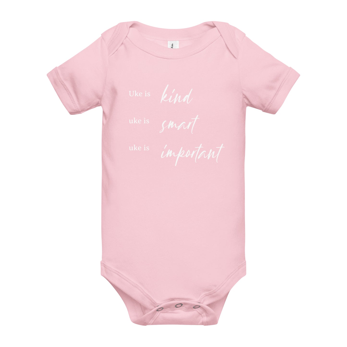 A light pink onesie printed with 'Uke is kind, uke is smart, uke is important' in white letters.