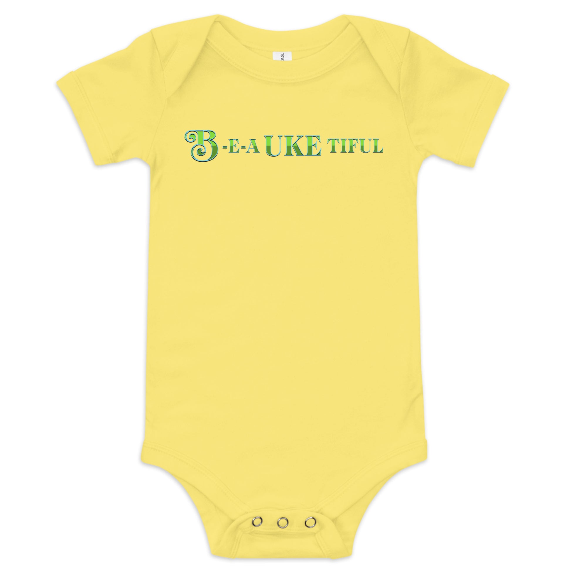 Yellow baby onesie with ‘B-E-A-UKE-tiful’ printed in green block letters with a decorative letter B.