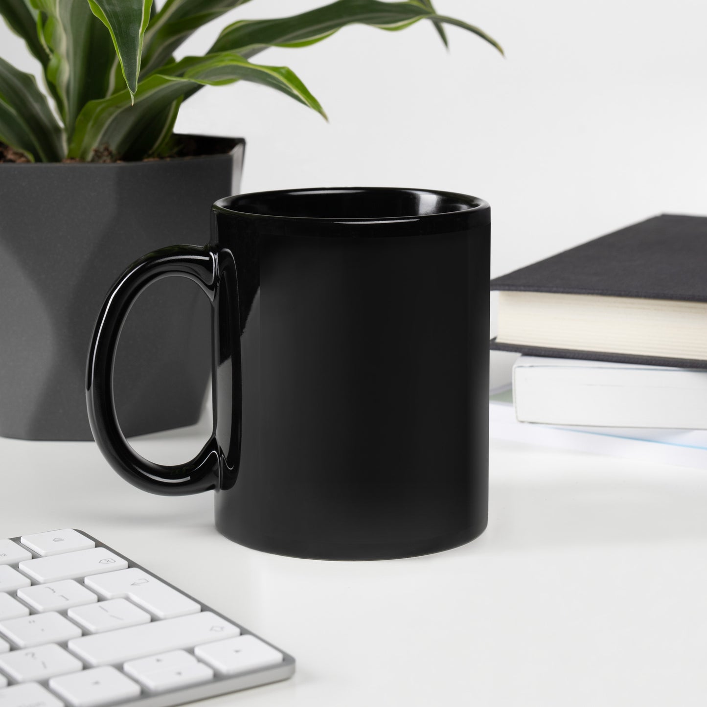 Unprinted side of a glossy black mug to illustrate that the graphic is printed on the side opposite the handle and not on the right or left.