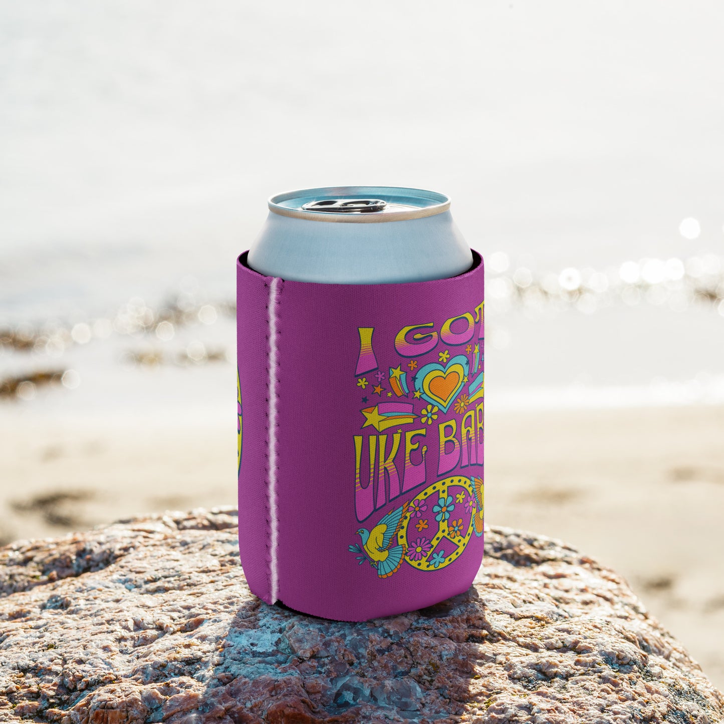 Regular-sized can coozie with a deep pink background and a pink, blue, and yellow 'I Got Uke Babe’ and peace sign graphic printed on it.