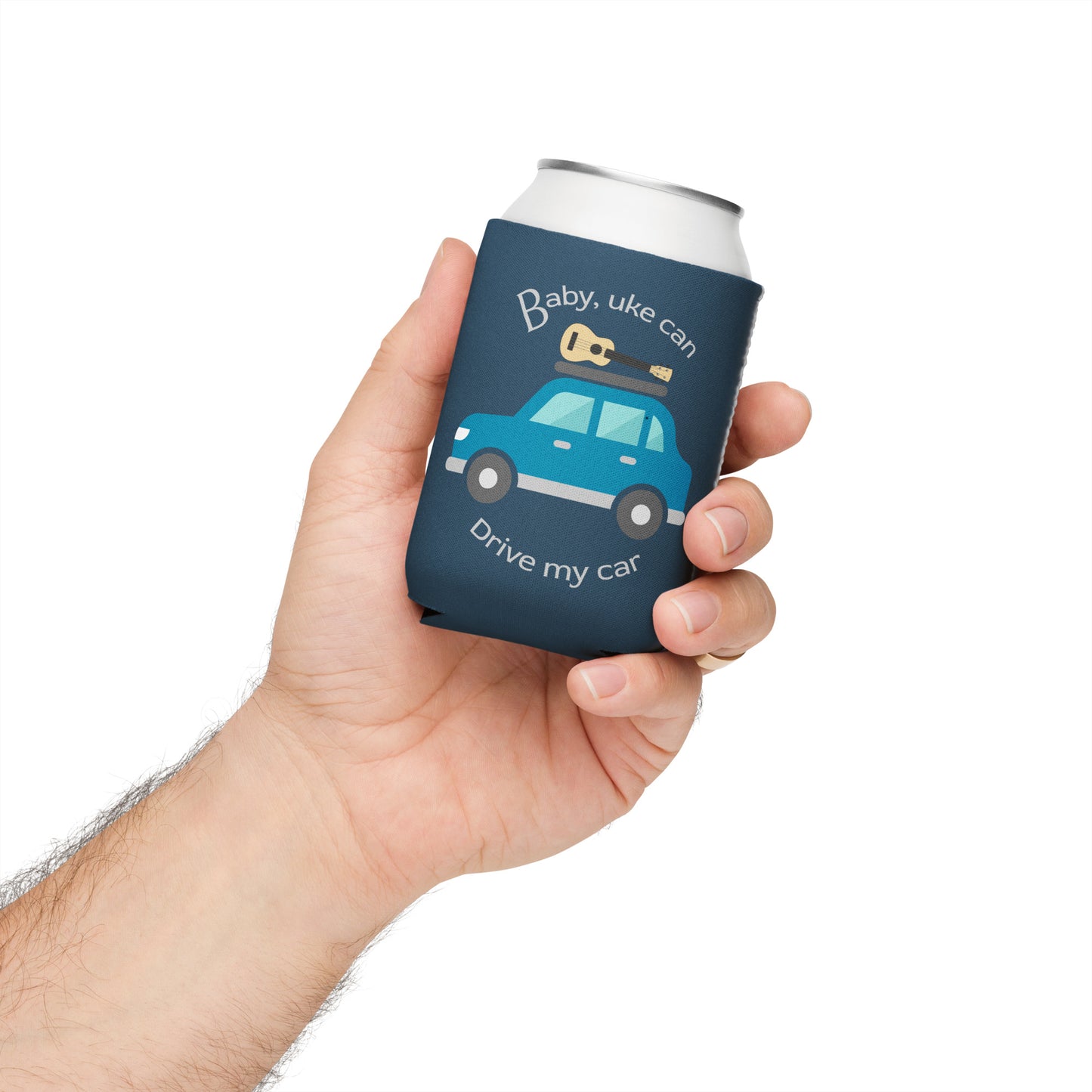 Hand holding a regular-sized can coozie printed with an indigo background and ‘Baby, uke can drive my car’ with a graphic of a car with a ukulele on the roof.