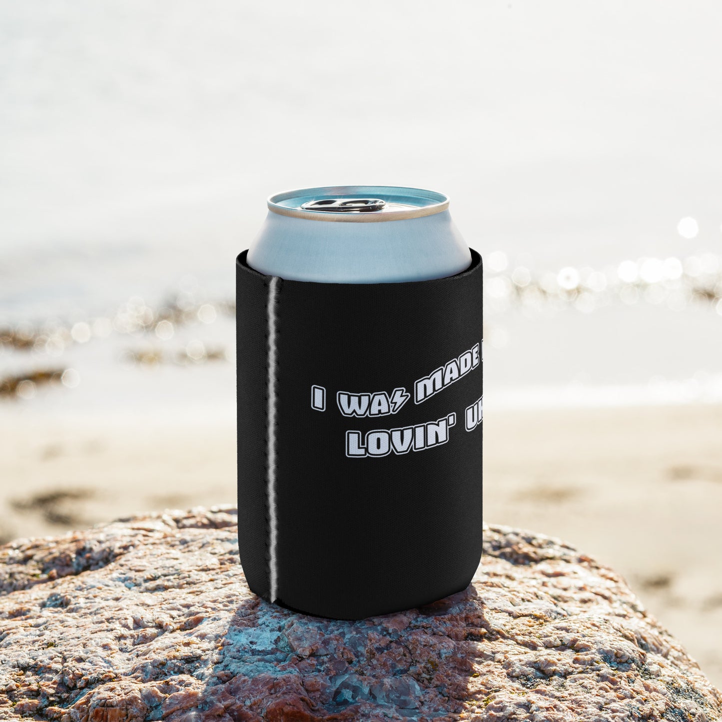 A regular-sized can coozie with a black background and 'I was made for lovin' uke' printed in black and white block letters.