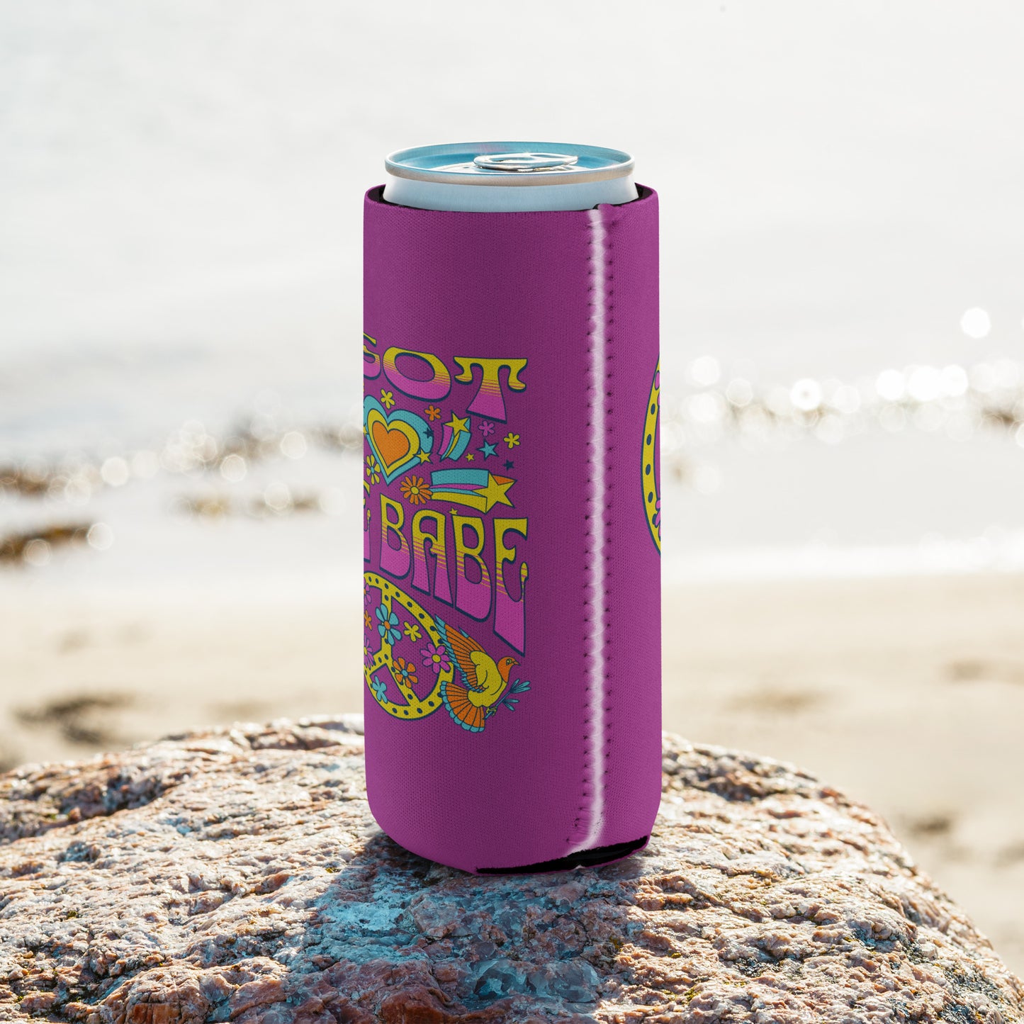 Slim can coozie with a deep pink background and a pink, blue, and yellow 'I Got Uke Babe’ and peace sign graphic printed on it.