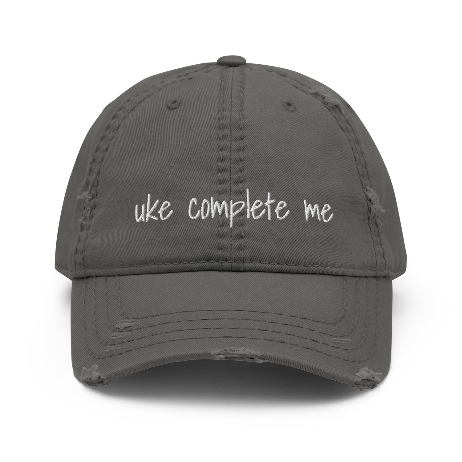 Grey baseball cap with a distressed look and 'Uke complete me' embroidered on it with white thread.
