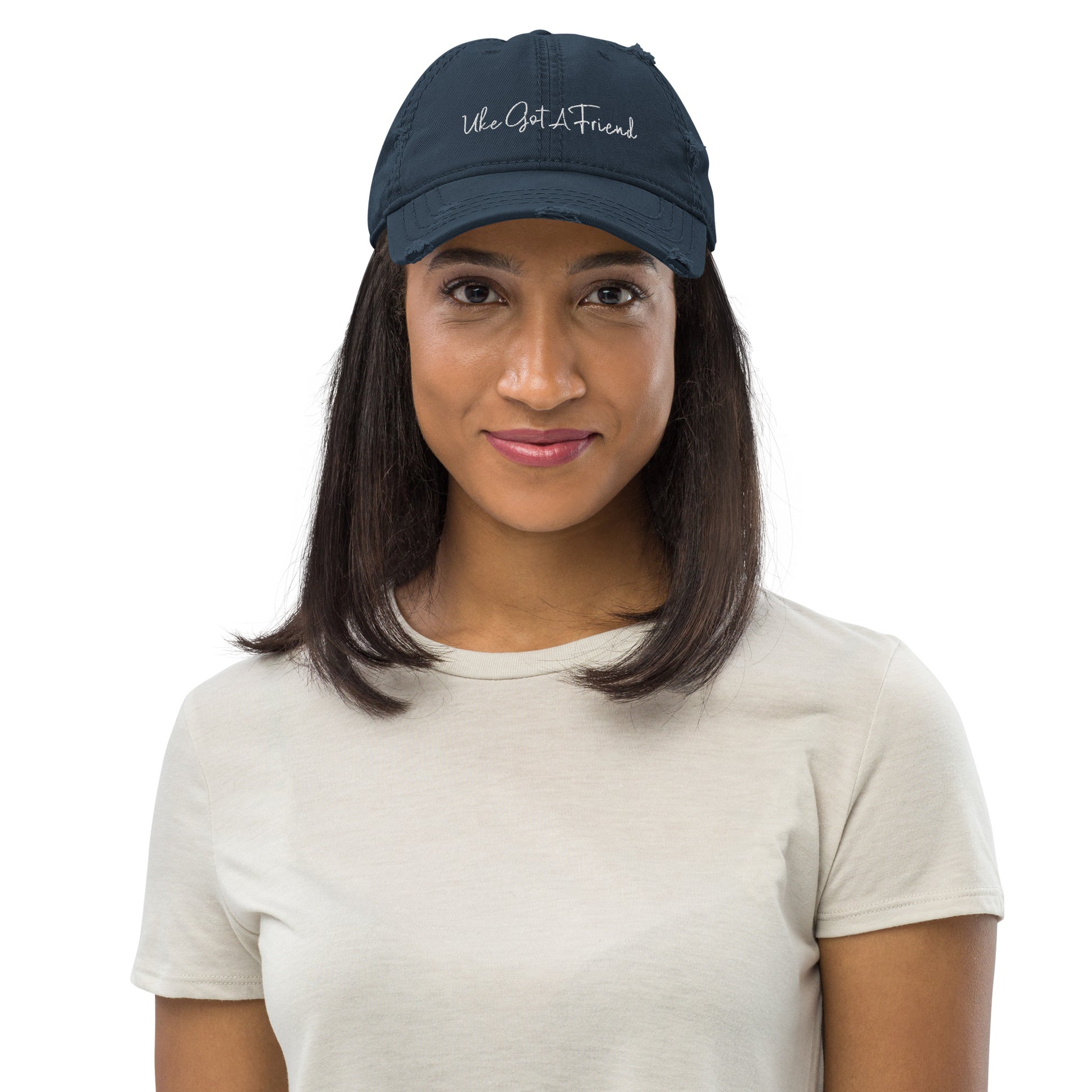 Woman wearing a navy-blue baseball cap with a distressed look and 'Uke Got A Friend' embroidered on it with white thread.