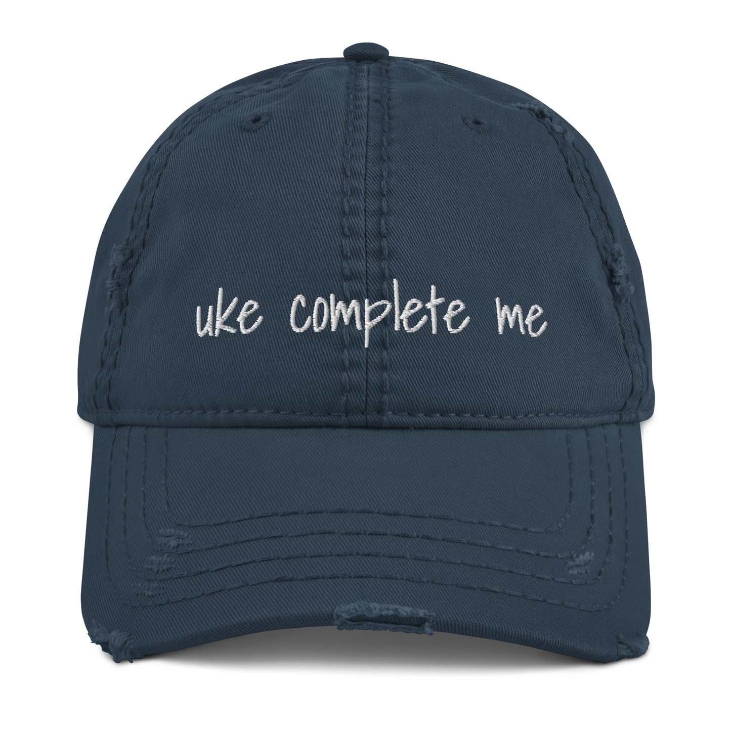 Navy-blue baseball cap with a distressed look and 'Uke complete me' embroidered on it with white thread.