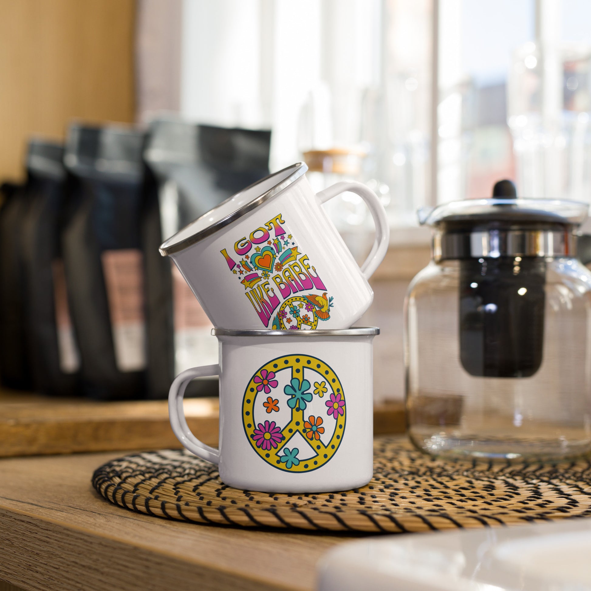 A stack of two white enamel mugs showing what both sides of a single mug look like. One side has 'I Got Uke Babe' and the other side has a pink, yellow, and blue peace sign graphic.