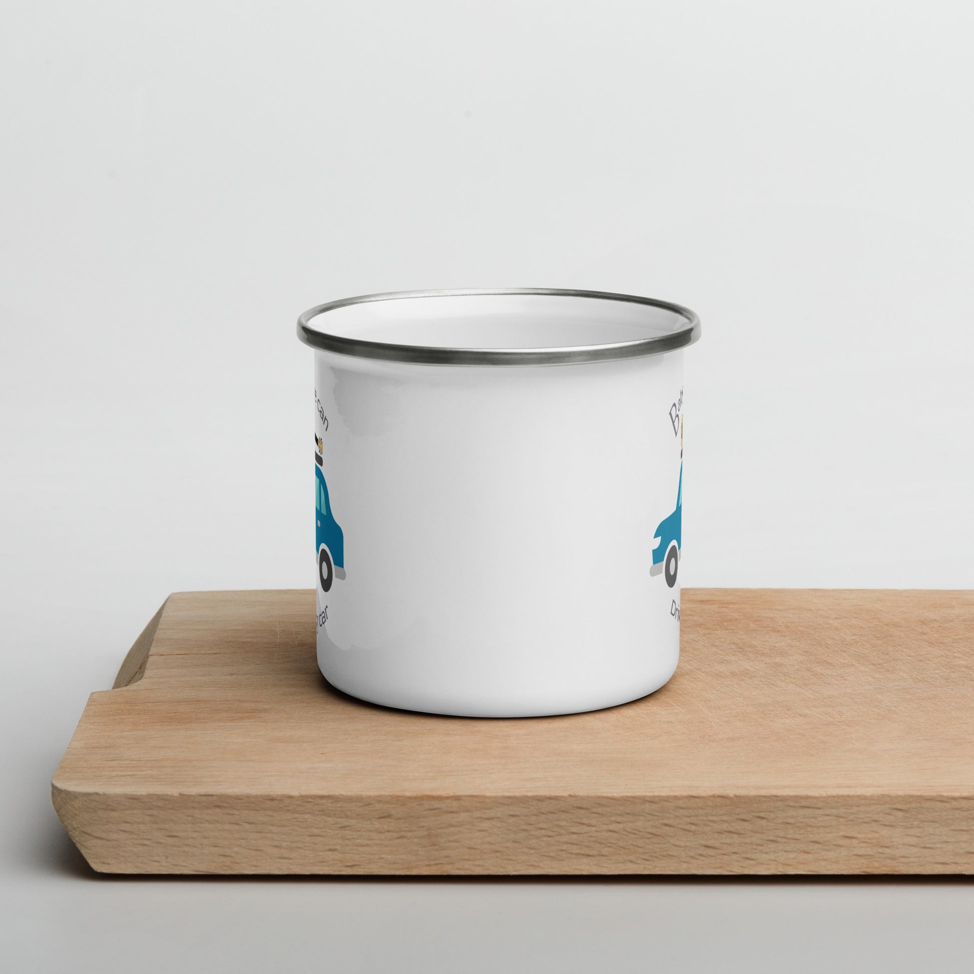 White enamel mug angled to illustrate that ‘Baby, uke can drive my car’ and a graphic of a car with a ukulele on the roof is printed on both sides of the mug handle.
