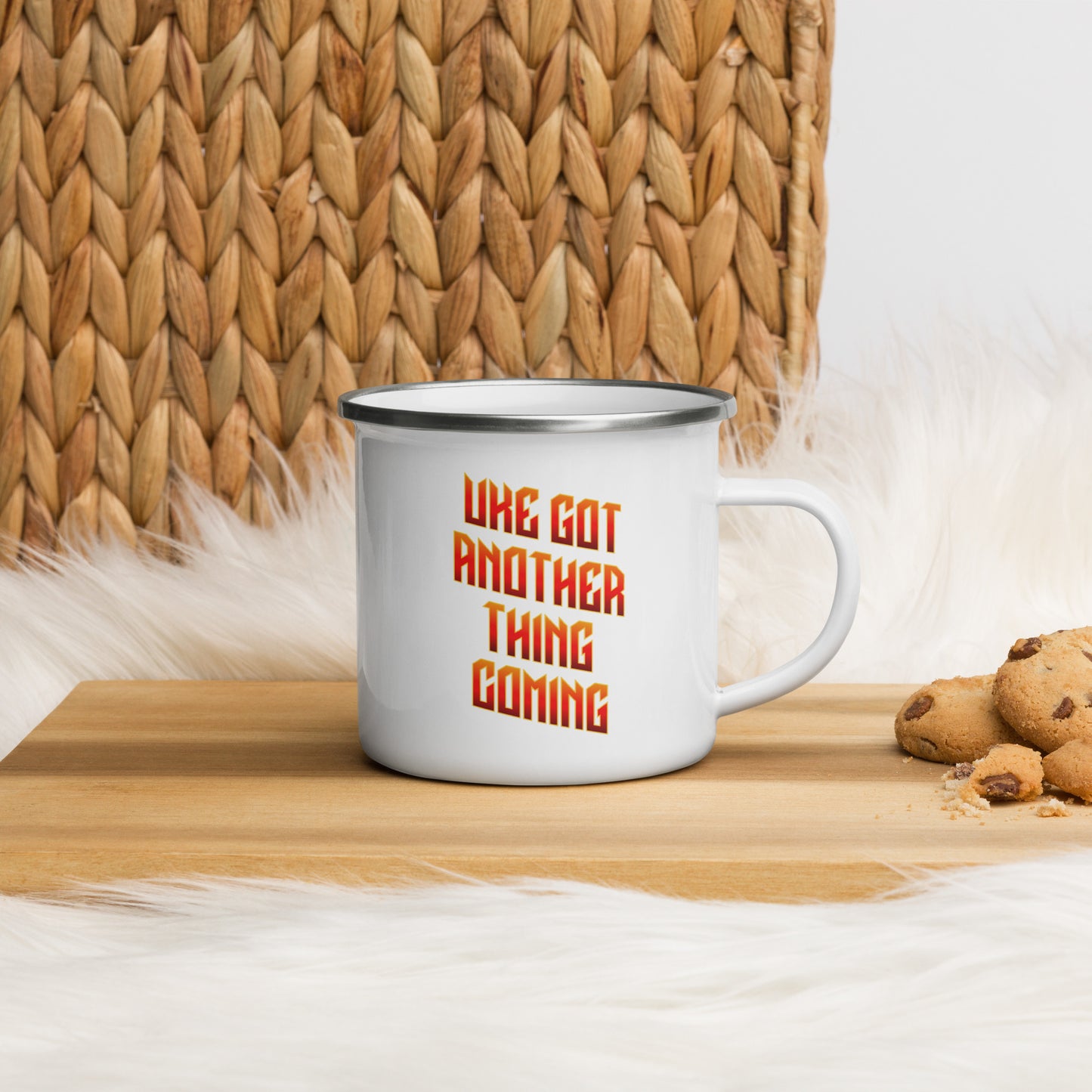 White enamel mug with ‘Uke Got Another Thing Coming' in orange and yellow slanted block letters printed on the side to the left of the mug handle.