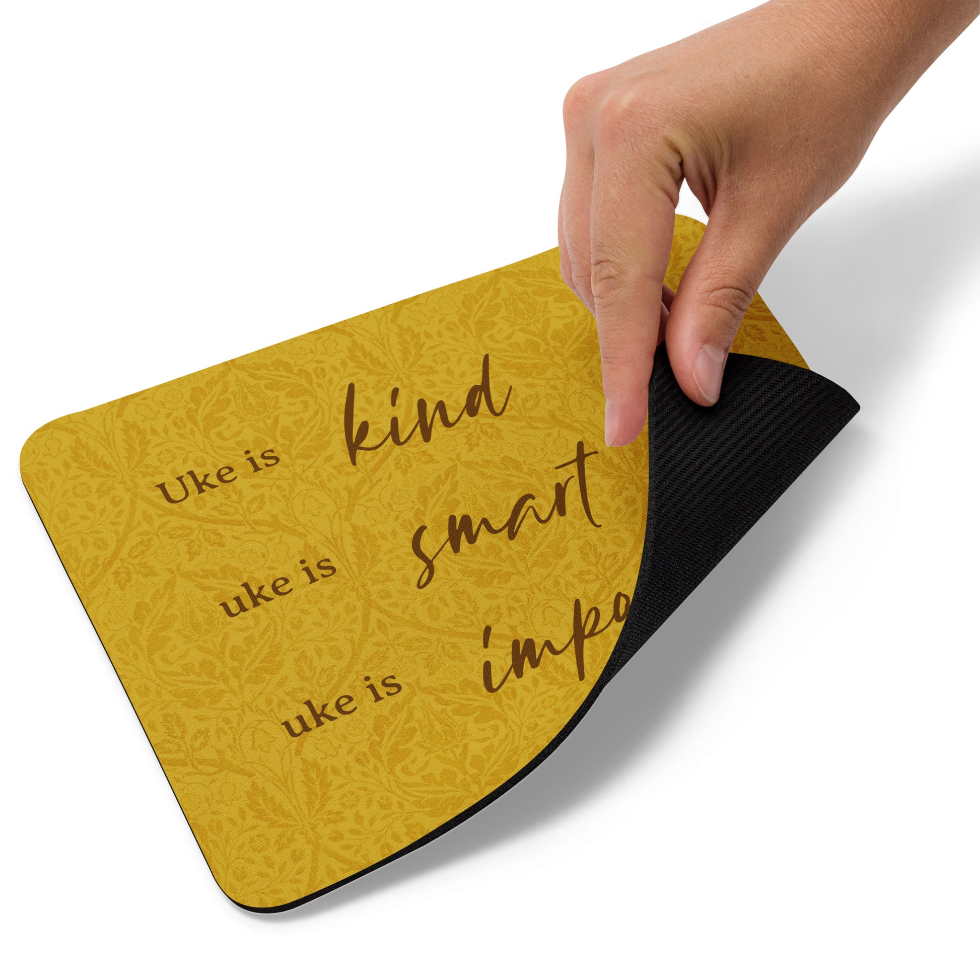 Mousepad with a mustard-colored, patterned background and 'Uke is kind, uke is smart, uke is important' printed on it.
