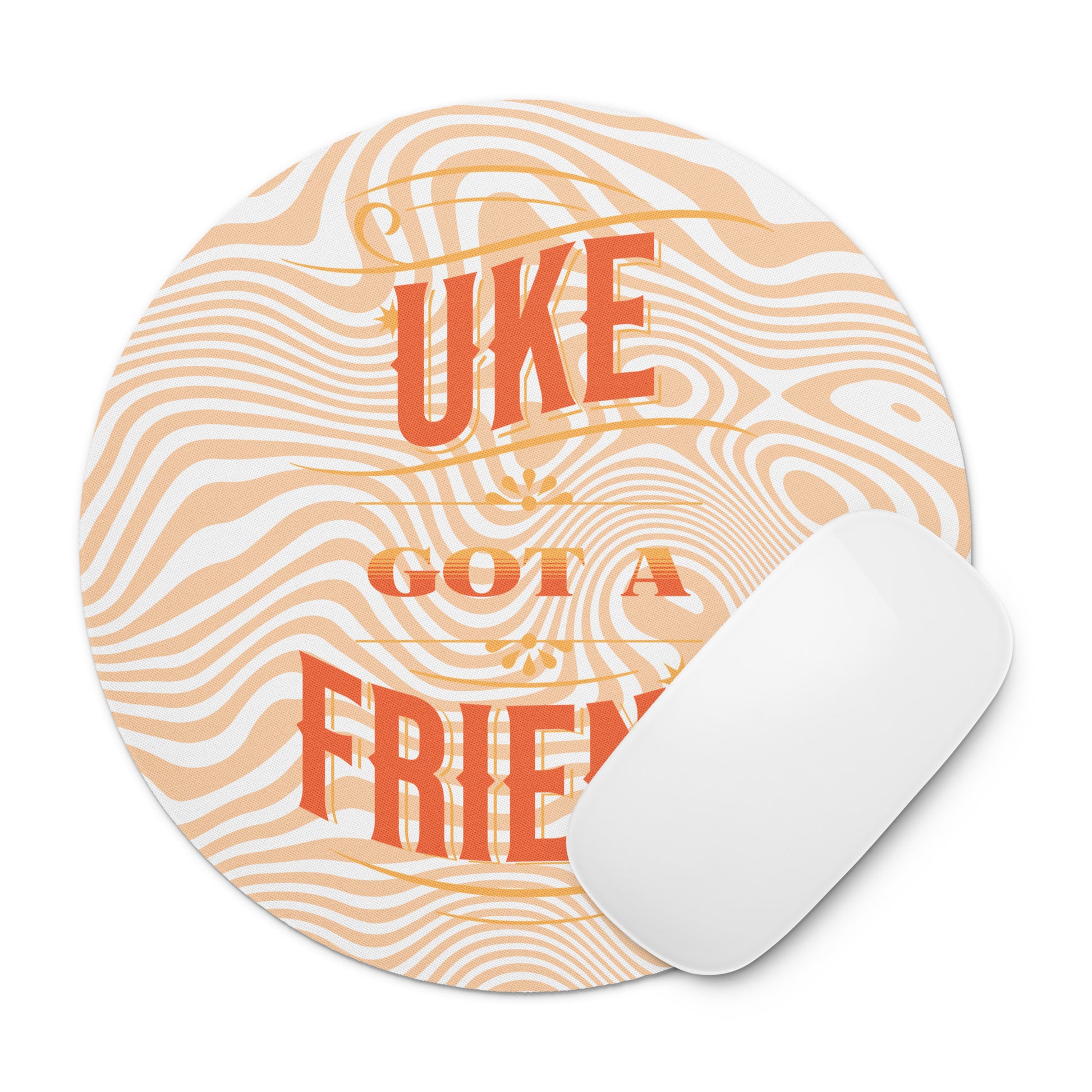 Round mouse pad with 'Uke Got A Friend' printed on it in orange and yellow block letters with a swirly design in the background and a mouse sitting on top of it.
