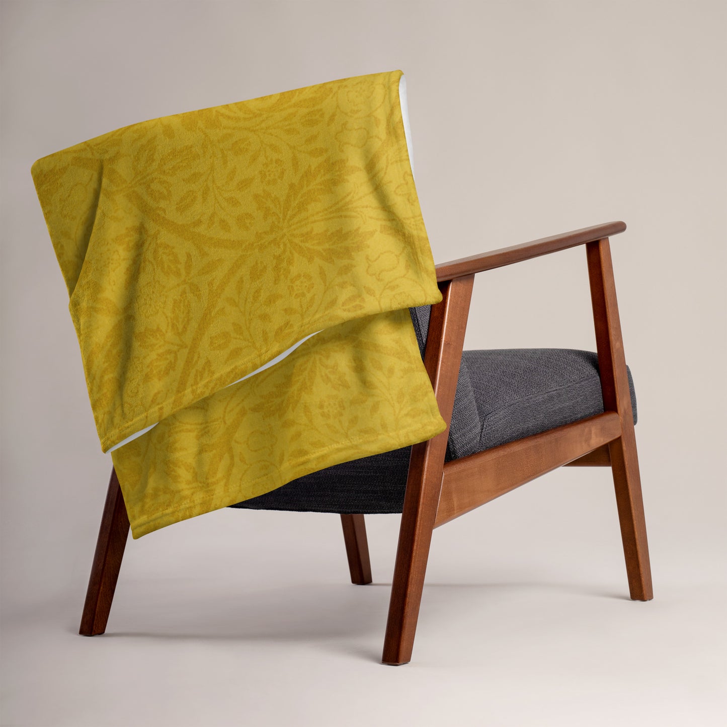 Close-up of the mustard-colored, patterned background of a microplush throw blanket.