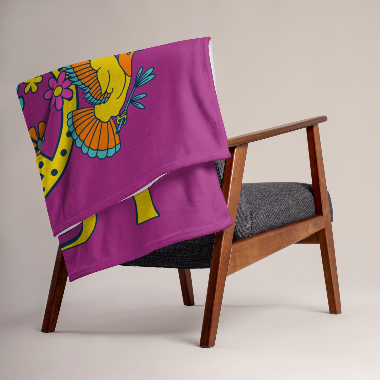 Microplush throw blanket with a dark pink background and a pink, blue, and yellow 'I Got Uke Babe' and peace sign graphic printed on it, folded and draped over a chair.
