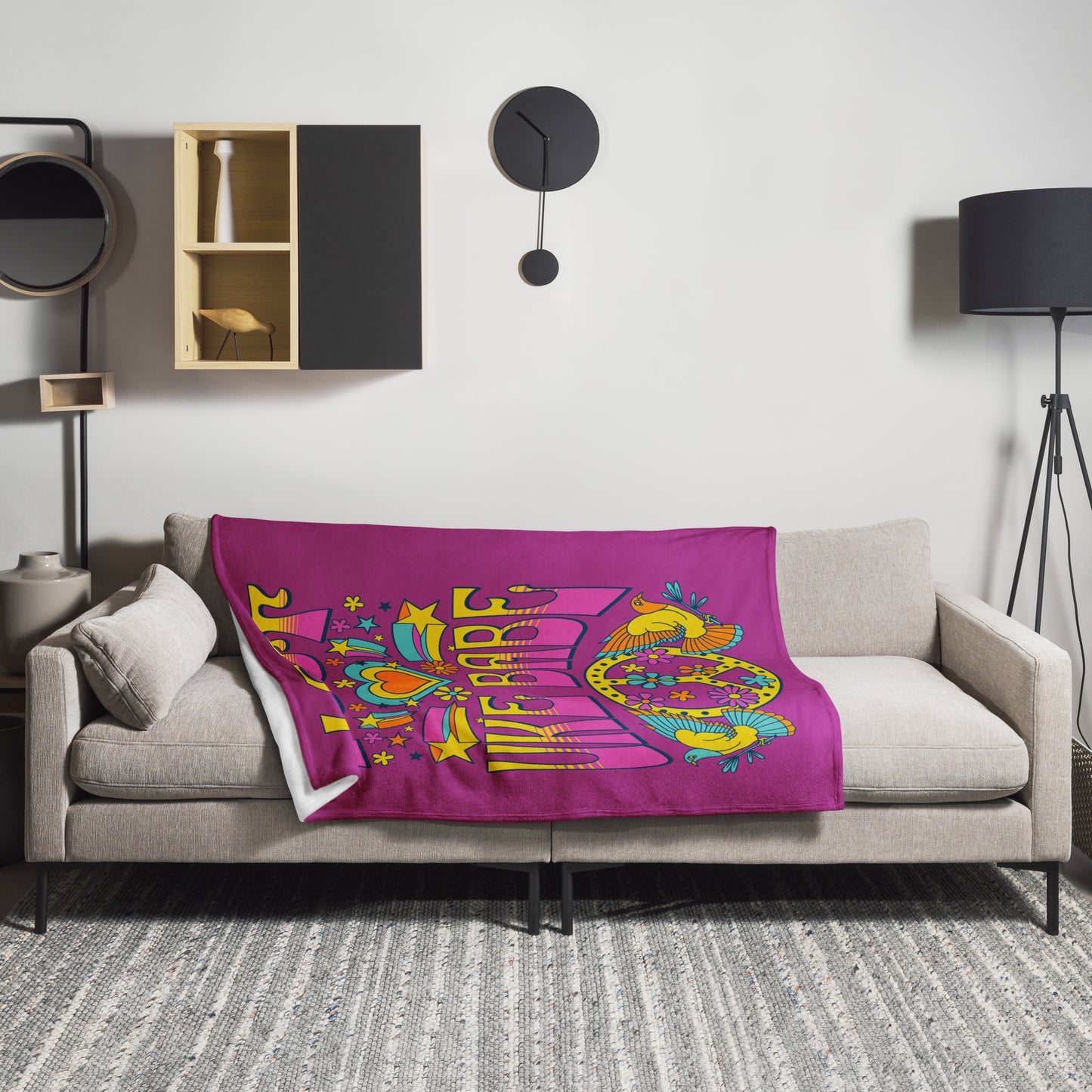 Microplush throw blanket with a dark pink background and a pink, blue, and yellow 'I Got Uke Babe' and peace sign graphic printed on it, draped over a sofa.