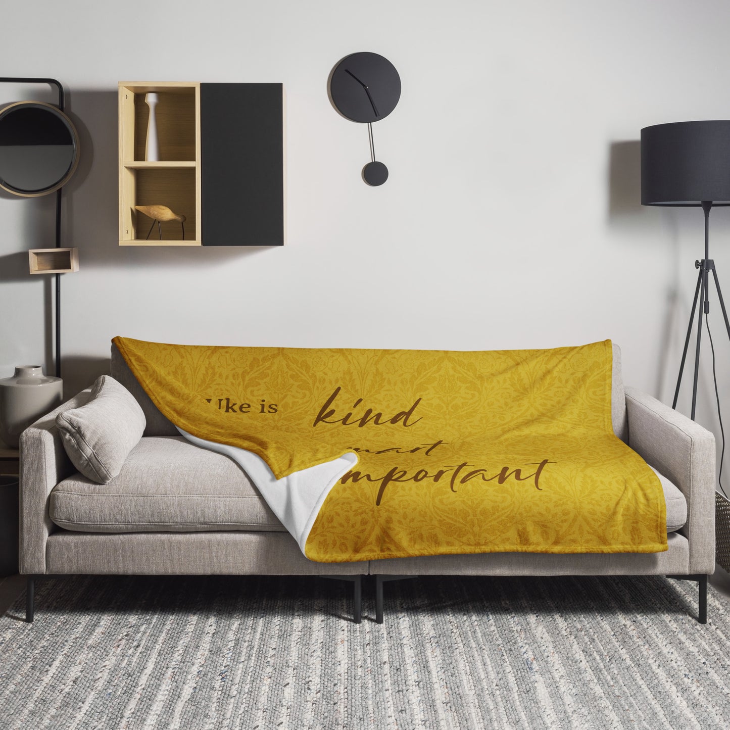 Microplush throw blanket with a mustard-colored, patterned background and 'Uke is kind, uke is smart, uke is important' printed on it, draped over a sofa.