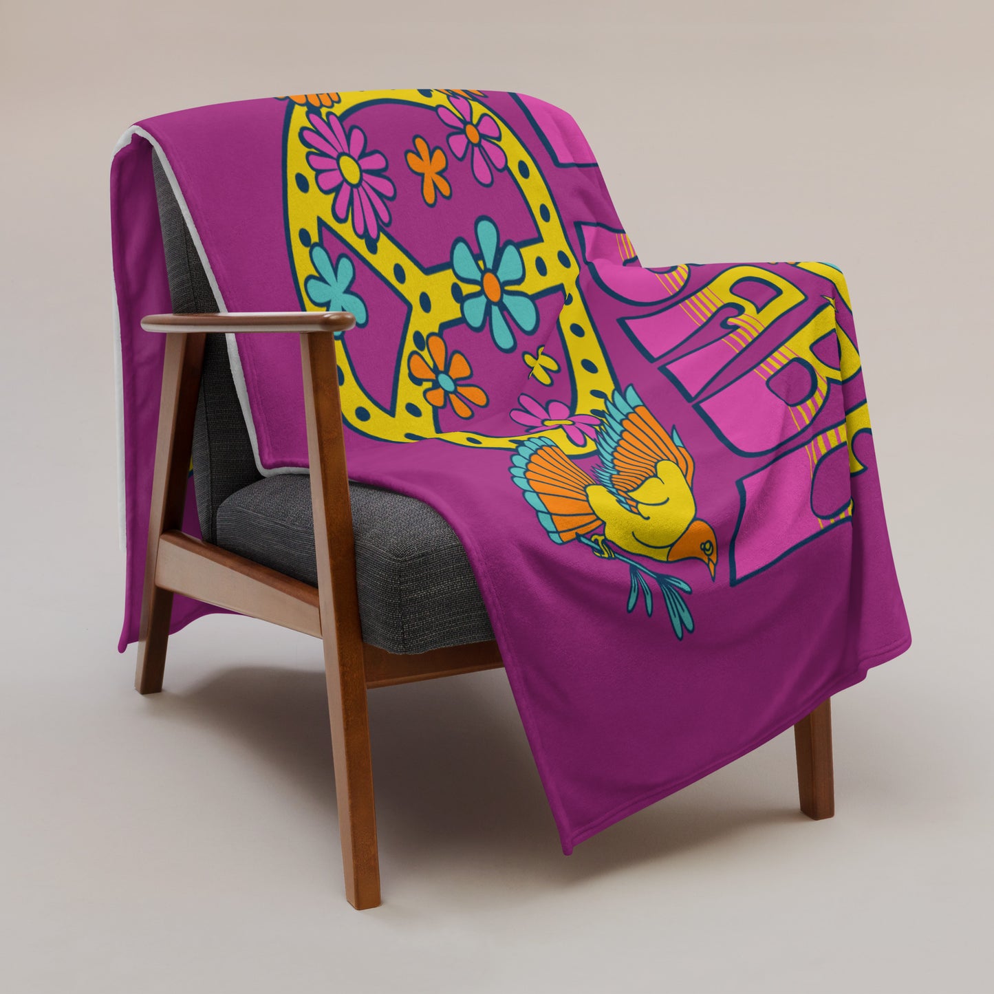 Microplush throw blanket with a dark pink background and a pink, blue, and yellow 'I Got Uke Babe' and peace sign graphic printed on it, draped over a chair.