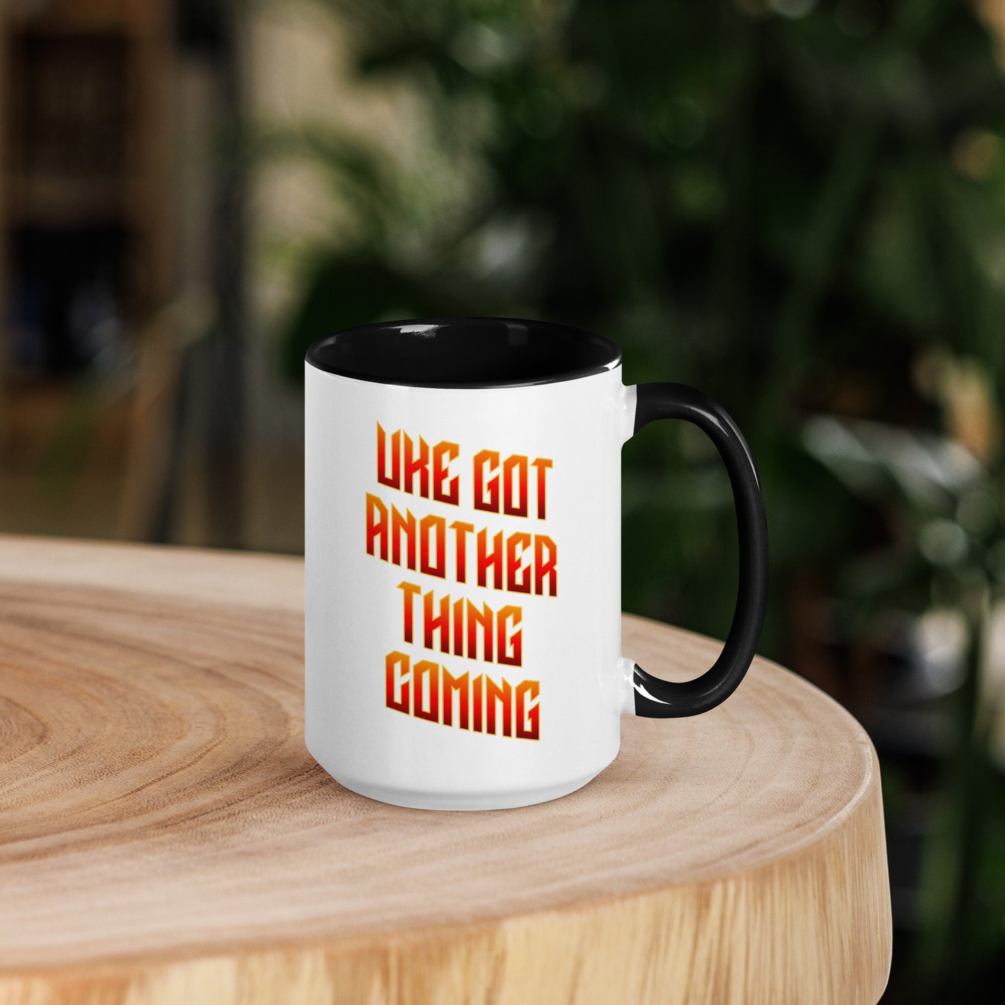 15-ounce white mug with black handle and inside, with ‘Uke Got Another Thing Coming' in orange and yellow slanted block letters printed on the side to the left of the handle.