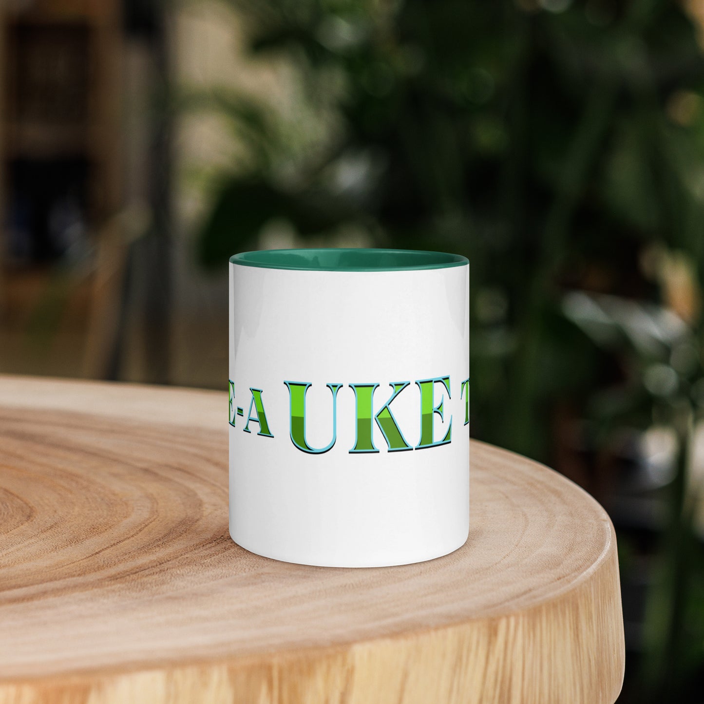 White mug with dark green handle and inside, with ‘B-E-A-UKE-tiful’ printed across the mug from one side of the handle to the other.