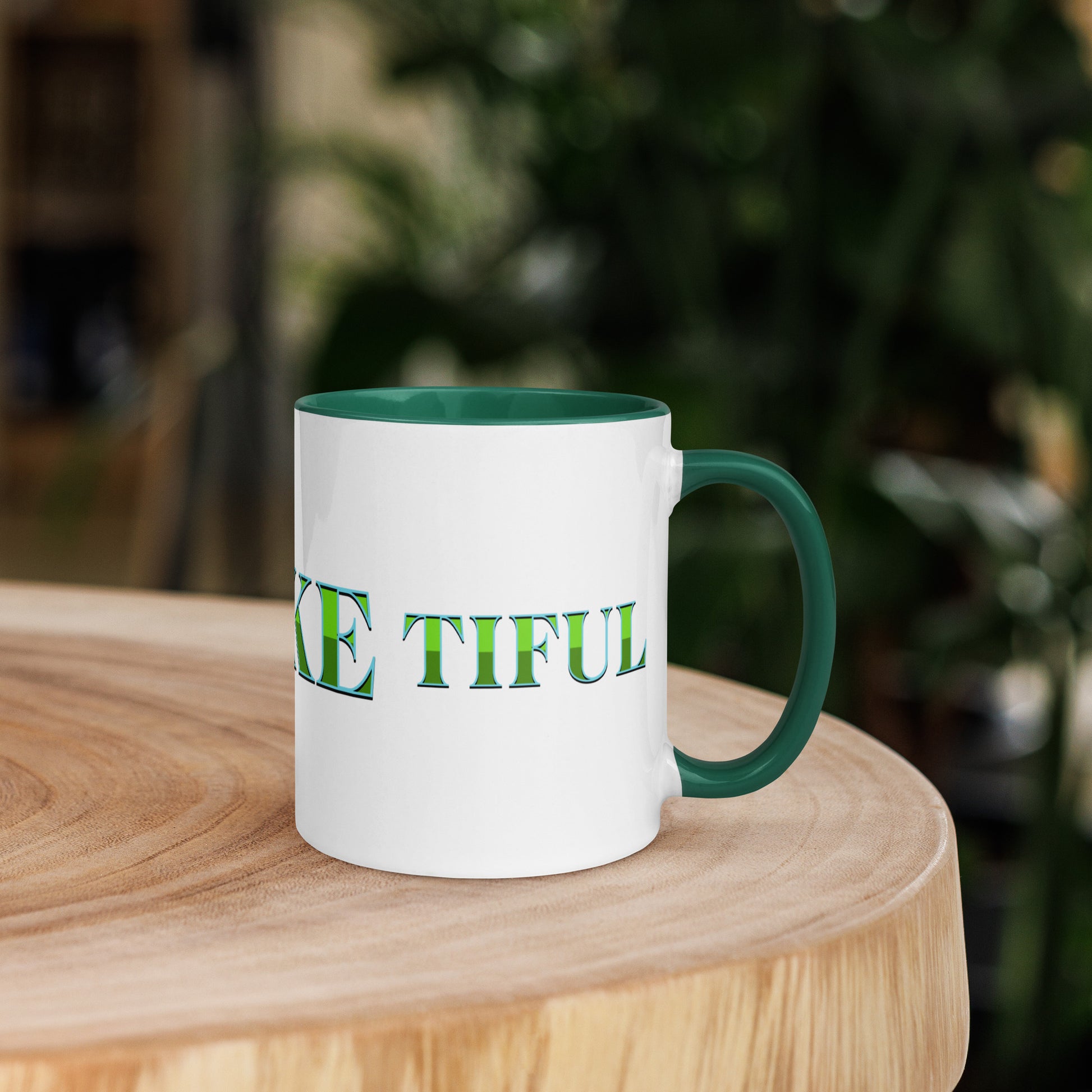 White mug with dark green handle and inside, with ‘B-E-A-UKE-tiful’ printed across the mug from one side of the handle to the other.