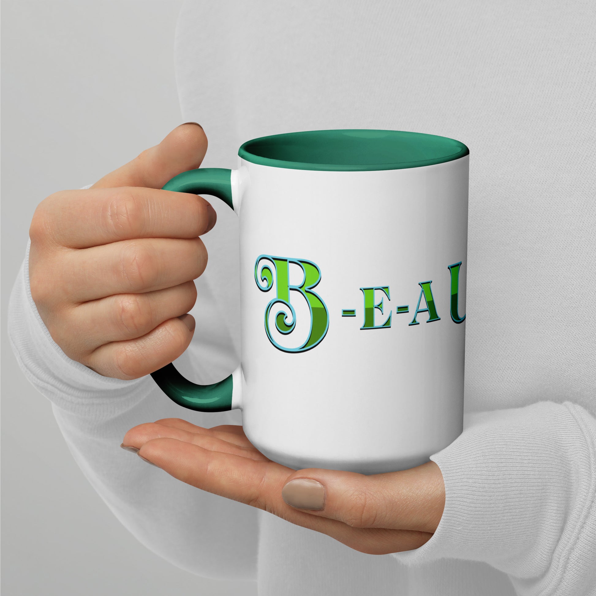 White mug with dark green handle and inside, with ‘B-E-A-UKE-tiful’ printed across the mug from one side of the handle to the other.