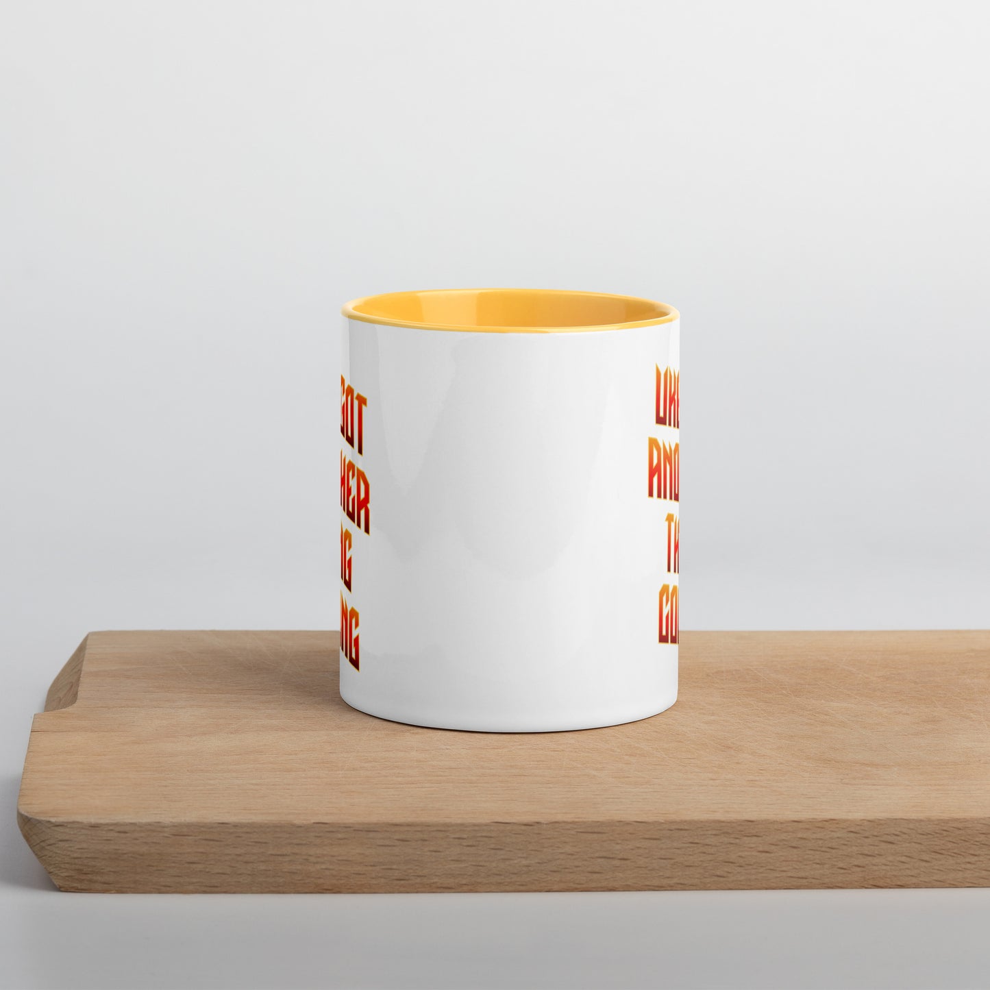 White mug with yellow handle and inside, with ‘Uke Got Another Thing Coming' in orange and yellow slanted block letters printed on both sides of the handle.