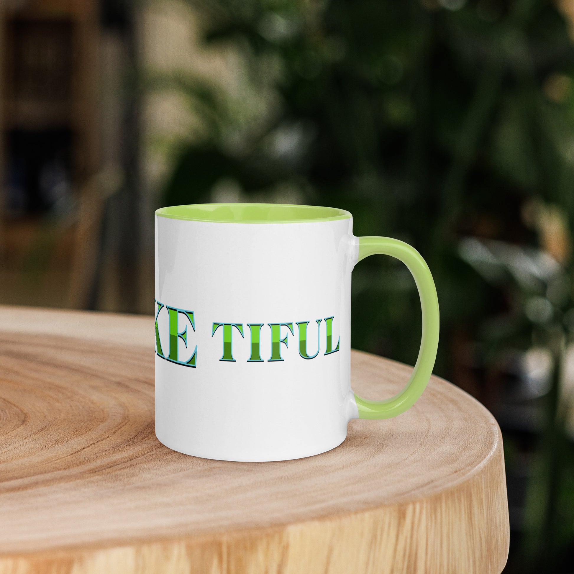 White mug with light green handle and inside, with ‘B-E-A-UKE-tiful’ printed across the mug from one side of the handle to the other.