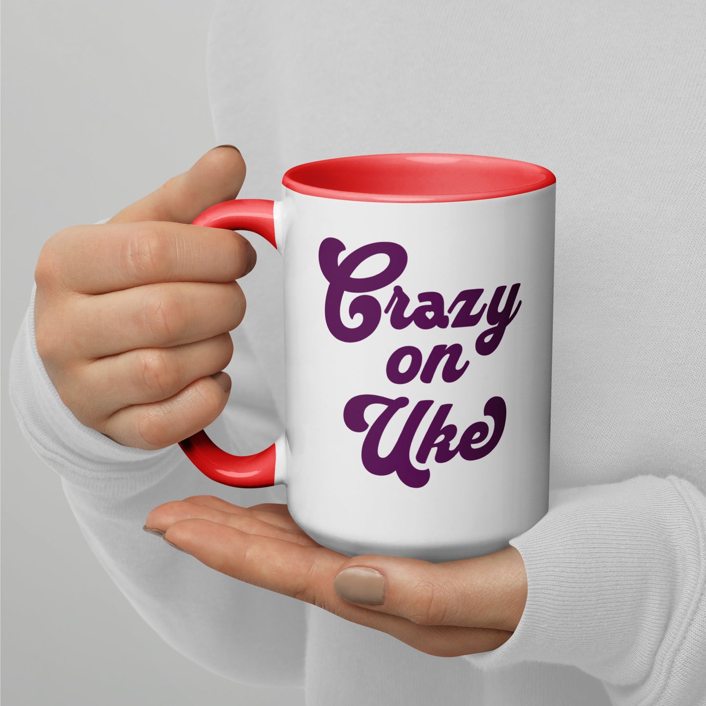 15-ounce white mug with red handle and interior, with 'Crazy On Uke' in purple cursive text printed on the side to the right of the handle.