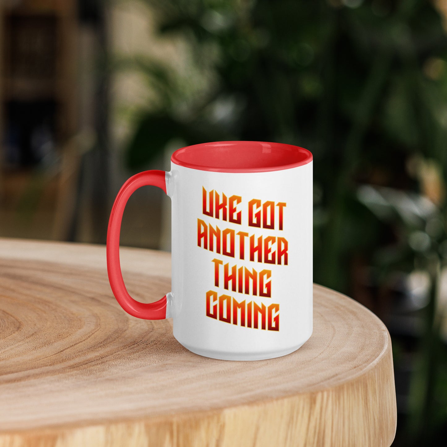 15-ounce white mug with red handle and inside, with ‘Uke Got Another Thing Coming' in orange and yellow slanted block letters printed on the side to the right of the handle.
