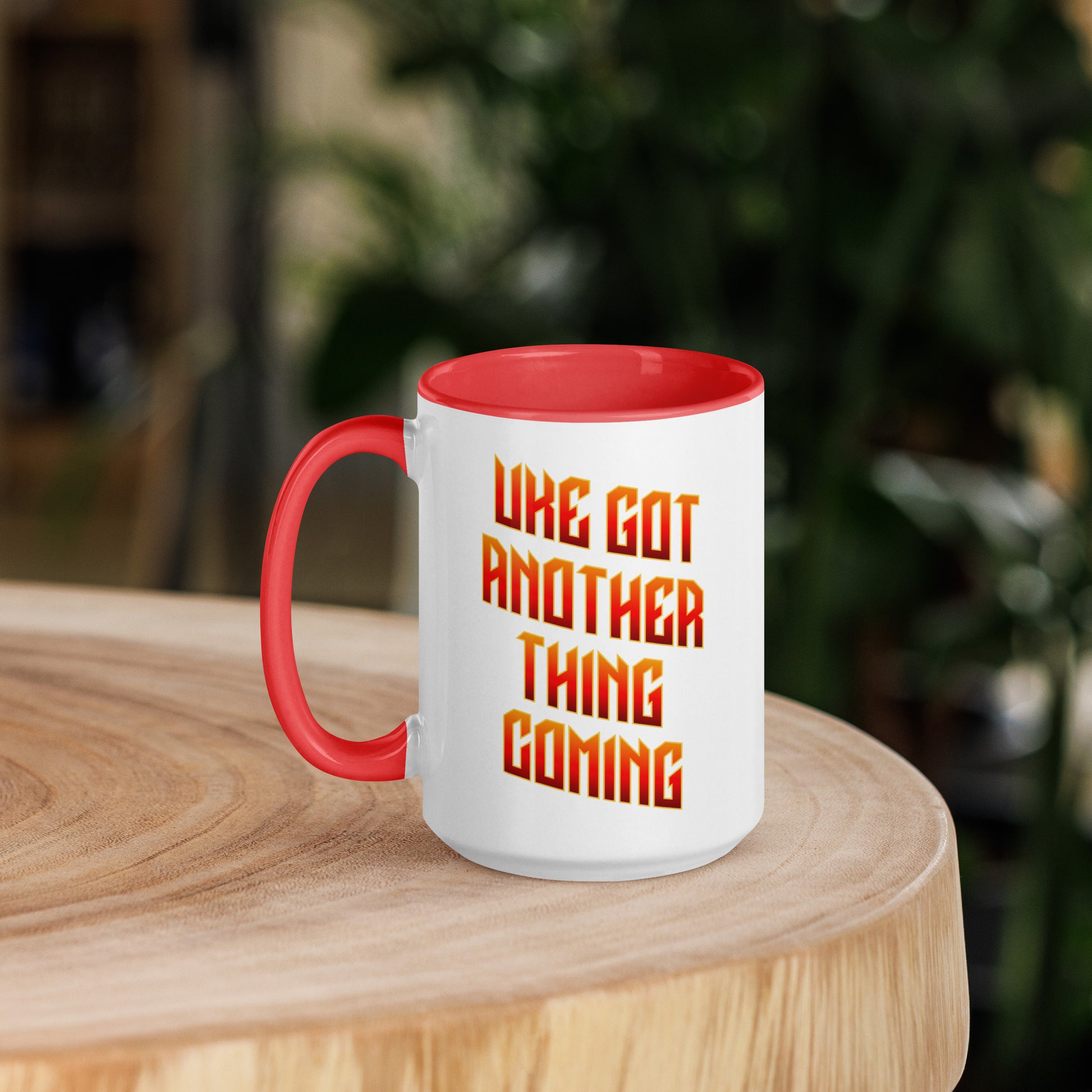 15-ounce white mug with red handle and inside, with ‘Uke Got Another Thing Coming' in orange and yellow slanted block letters printed on the side to the right of the handle.