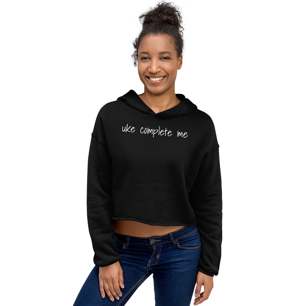Woman wearing a black cropped hoodie with 'uke complete me' written in white text.