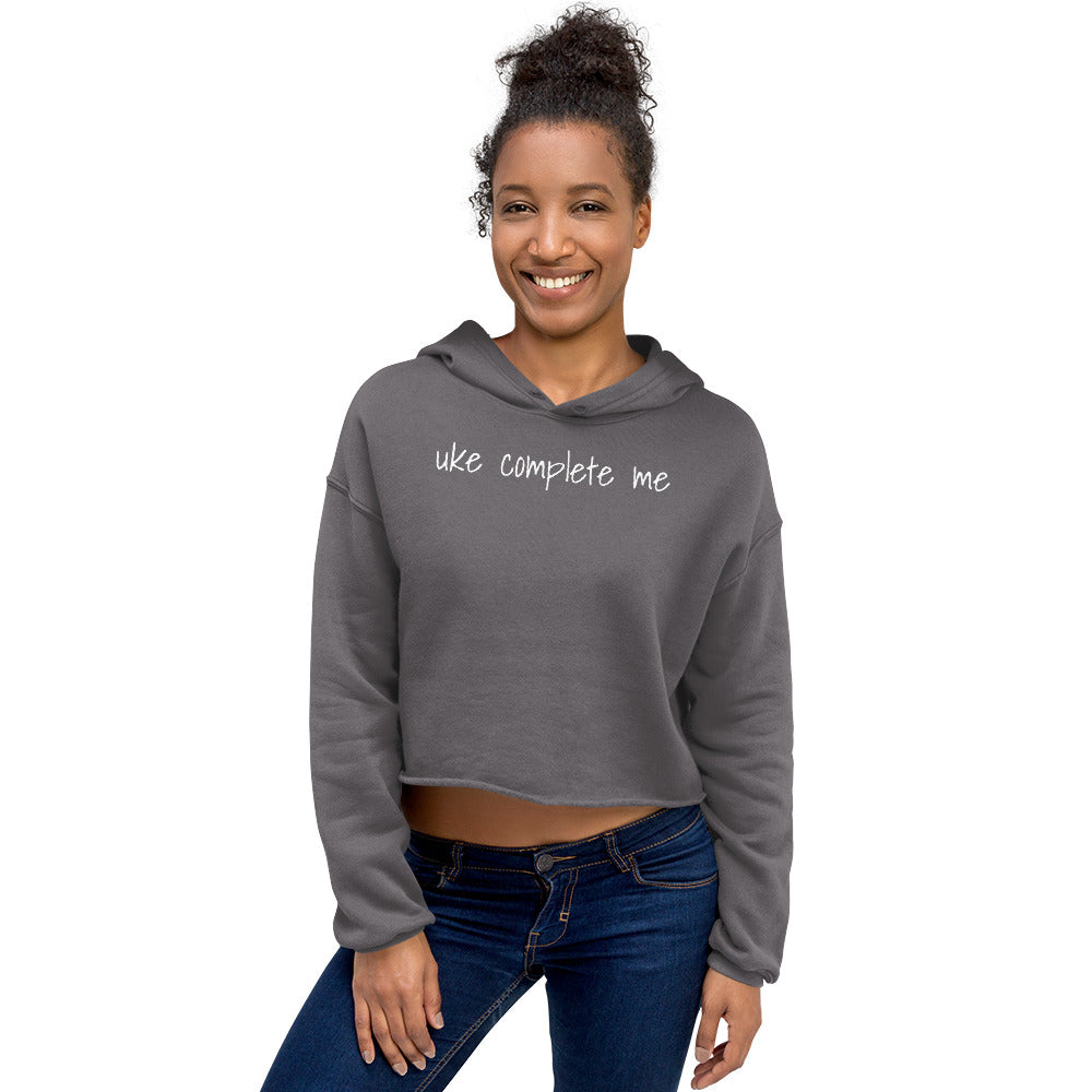 Woman wearing a Storm Front Grey cropped hoodie with 'uke complete me' written in white text.