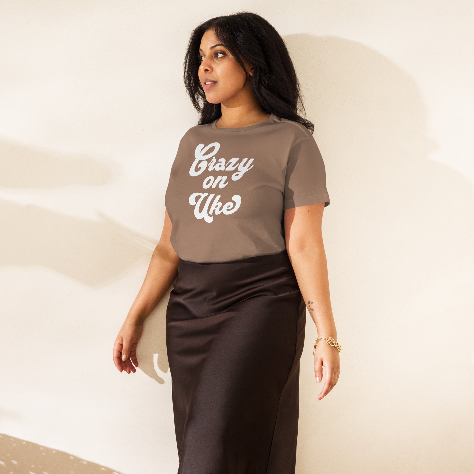 Woman wearing a latte-brown high-waisted t-shirt with 'Crazy On Uke' in white cursive text.