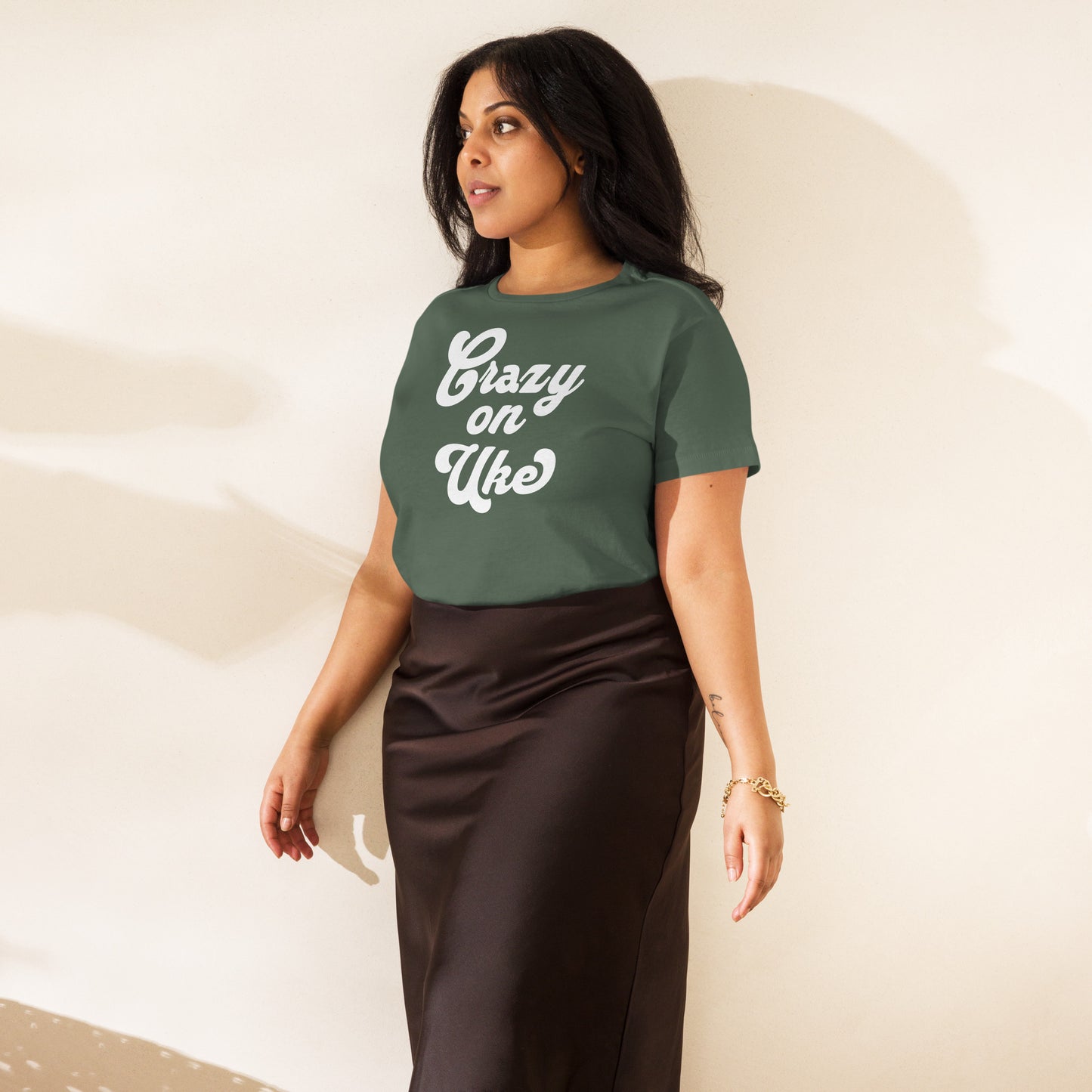 Woman wearing a pine-green high-waisted t-shirt with 'Crazy On Uke' in white cursive text.