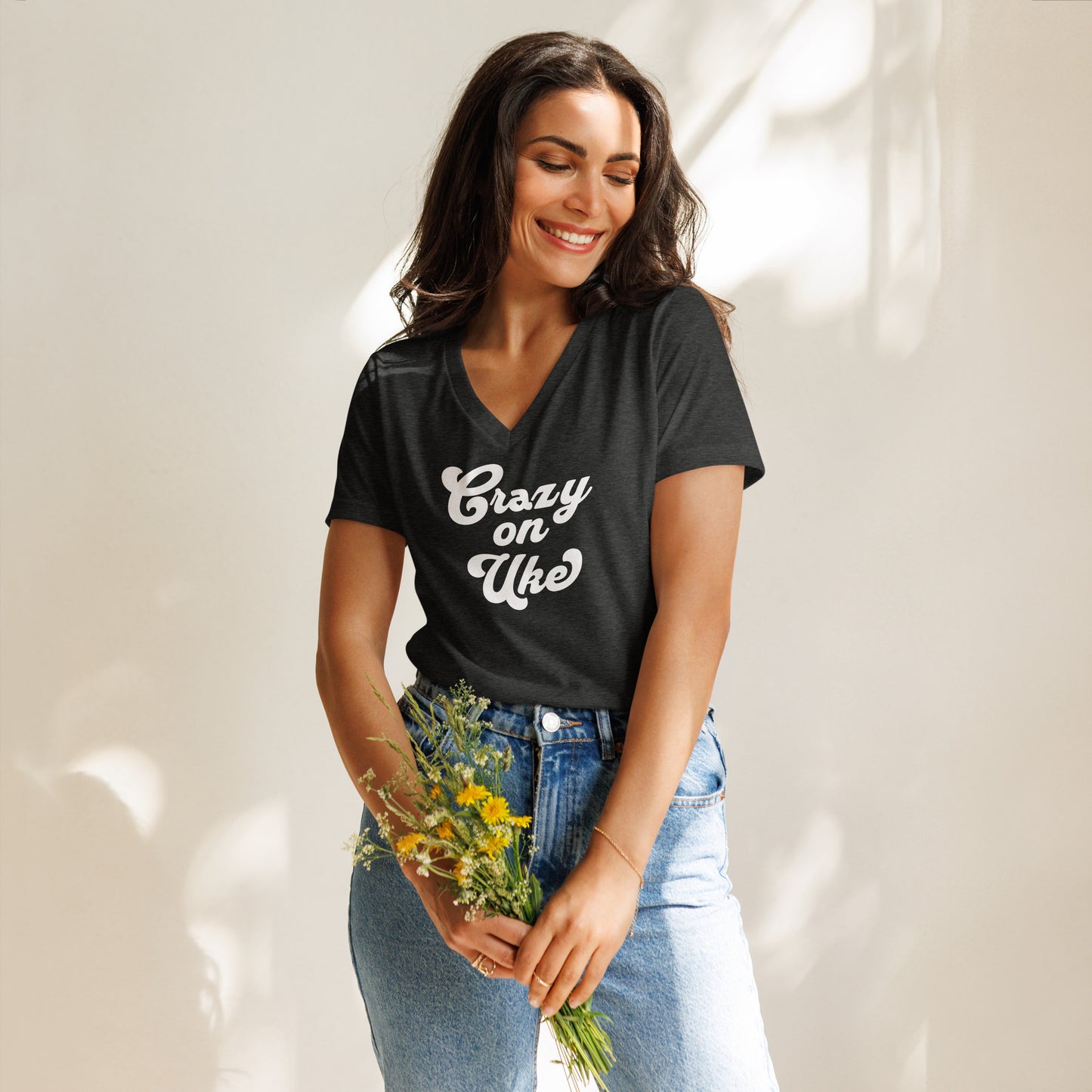 Woman wearing a dark grey v-neck t-shirt with 'Crazy On Uke' in white cursive text.